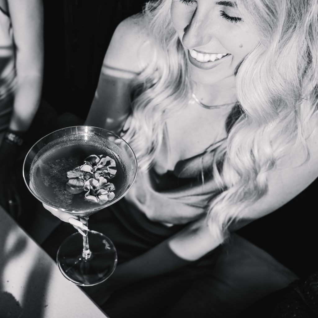 Black/white image of woman holding a cocktail made with Summer Storm Moonshine